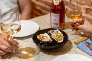 Pratos e vinhos da Cellar Cave no restaurante na Vila Nova Conceição, com ostras frescas e taças de vinho branco e rosé em ambiente aconchegante.