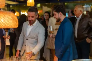 Homens apreciando vinhos em evento corporativo no restaurante Cave da cellar vinhos, com ambiente sofisticado e clima de networking