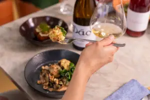  Vaso de vinho branco, pratos de aperitivos e comida sofisticada em um menu almoço no cellar cave, ambiente elegante para refeições especiais.